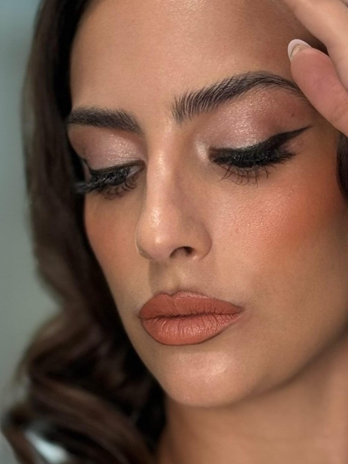 Beauty close-up — graphic cut-crease liner, feathered brows, glass skin